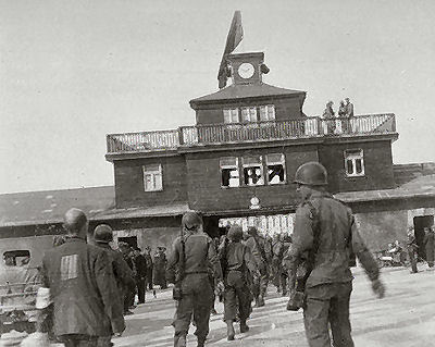 American soldiers and liberated prisoners at the main entrance of the Buchenwald concentration camp. Germany, May 1945.