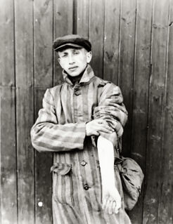 A survivor of the Buchenwald concentration camp displays his tattooed arm. Apr-May 1945.